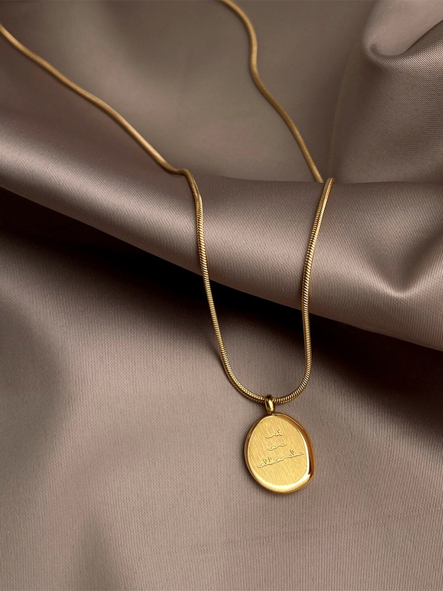 Nahaufnahme: Adorable Halskette mit Gravur-Charm am Hals getragen – minimalistische Perlenkette mit personalisierbarem Goldelement