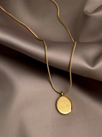 Nahaufnahme: Adorable Halskette mit Gravur-Charm am Hals getragen – minimalistische Perlenkette mit personalisierbarem Goldelement
