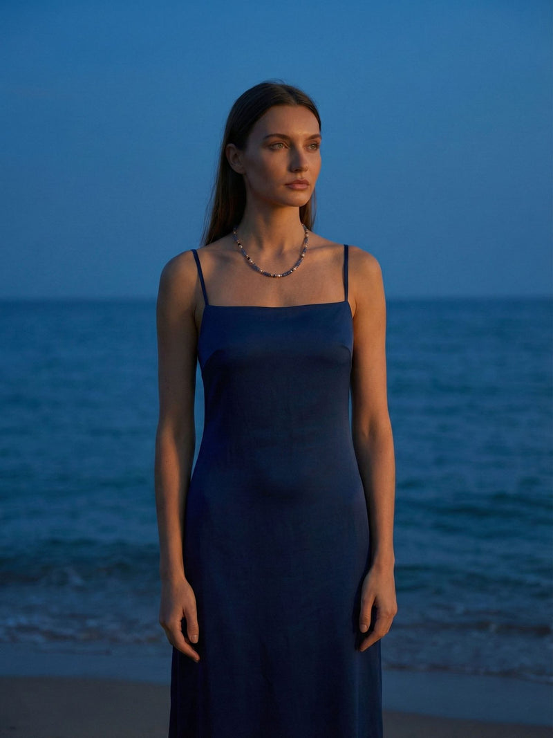 Sodalith Kette Ocean Night Komplettlook - Model im dunkelblauen Kleid am Strand bei Abenddaemmerung