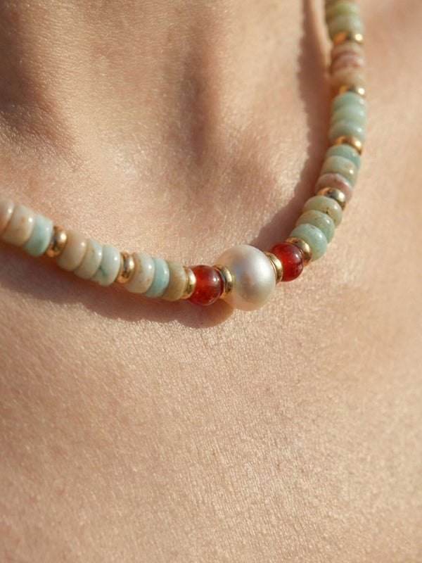 Nahaufnahme Sommerglanz Kette am Hals mit Suesswasserperle roten Achat-Perlen und goldenen Zwischenperlen auf Haut