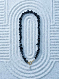 Nemomatheo Midnight Pearl Kette auf Zen-Sandhintergrund – Elegante Obsidian-Perlenkette Flatlay