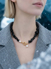 Frau trägt Midnight Pearl Obsidian-Kette – Nemomatheo handgefertigte Naturstein-Halskette mit Perlenanhänger