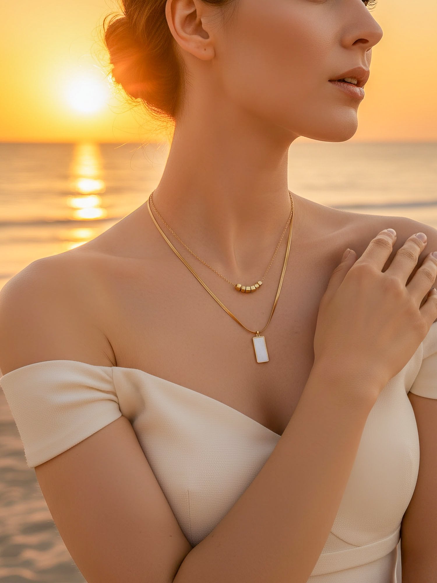 Nahaufnahme der Urban Mirror Kette am Dekolleté – filigraner Goldschmuck mit reflektierendem Charm und Süßwasserperlen