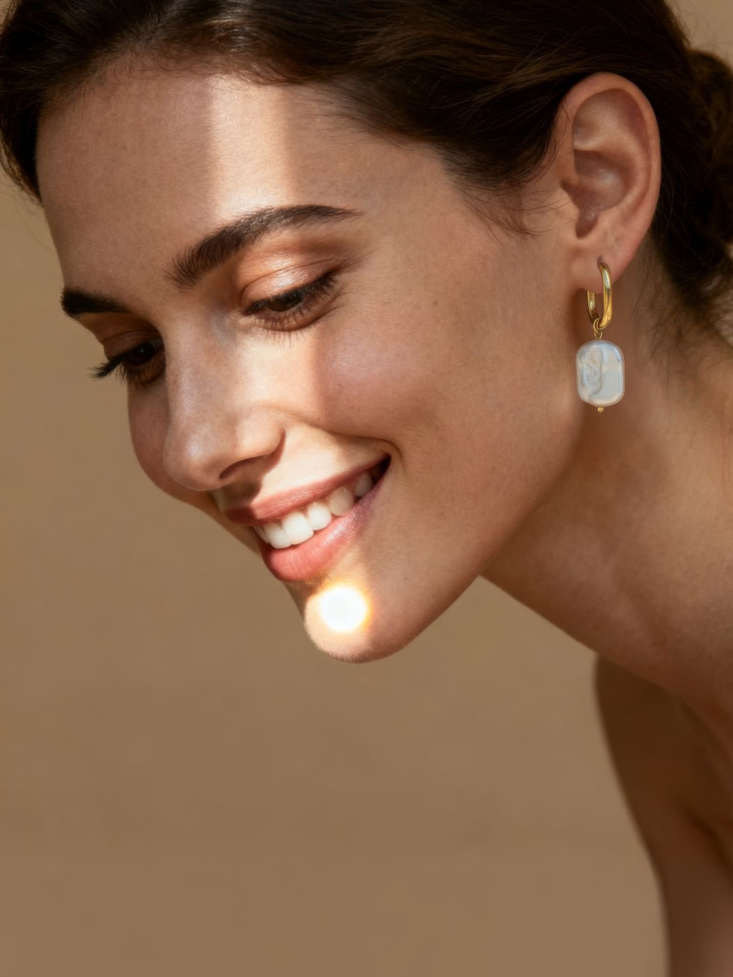 Marea Ohrringe Lifestyle – Frau trägt goldene Perlenohrringe im Freien mit natürlichem Licht