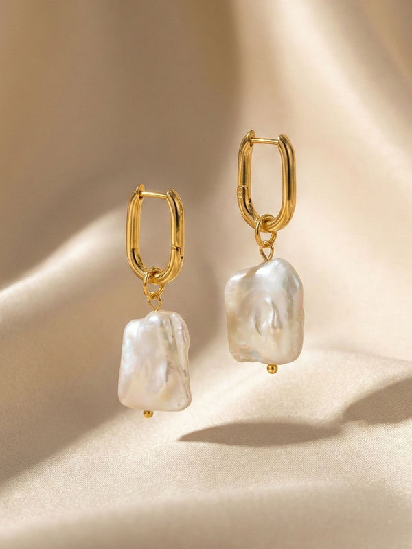 Marea Ohrringe auf beigem Satin – Goldene Huggie Hoops mit Barockperlen Flatlay elegante Produktfotografie
