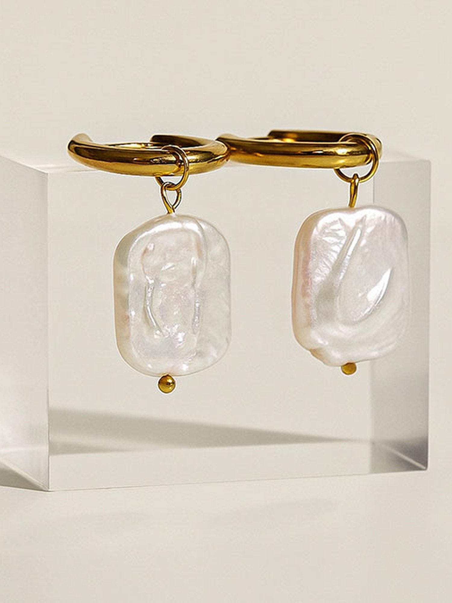 Marea Ohrringe Studioaufnahme – symmetrische Produktfotografie goldener Creolen mit Barockperlen