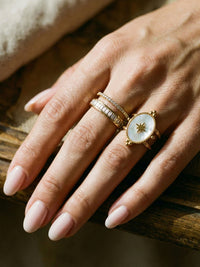 Morning Star Perlmutt Ring am Finger getragen auf Holztisch natuerliches Licht Nemomatheo