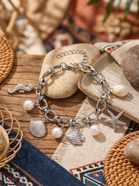 Armband Ocean Treasure – Meeres-Charm Armband mit Süßwasserperlen, Seestern und Muschel, silberfarben – Produktansicht im Stillleben