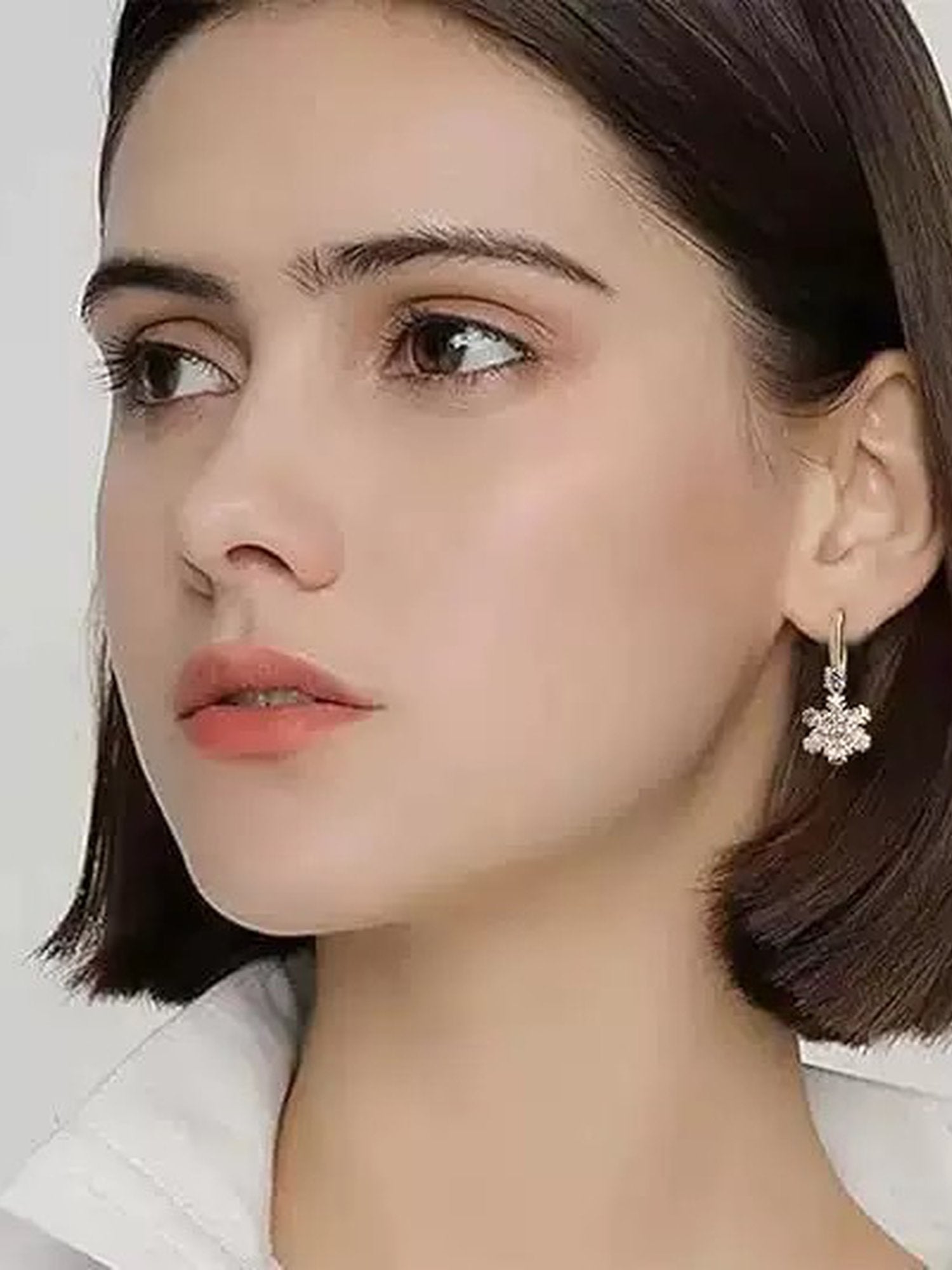 Golden Snowflakes Ohrringe getragen – Frau trägt vergoldete Schneeflocken-Ohrringe elegant am Ohr