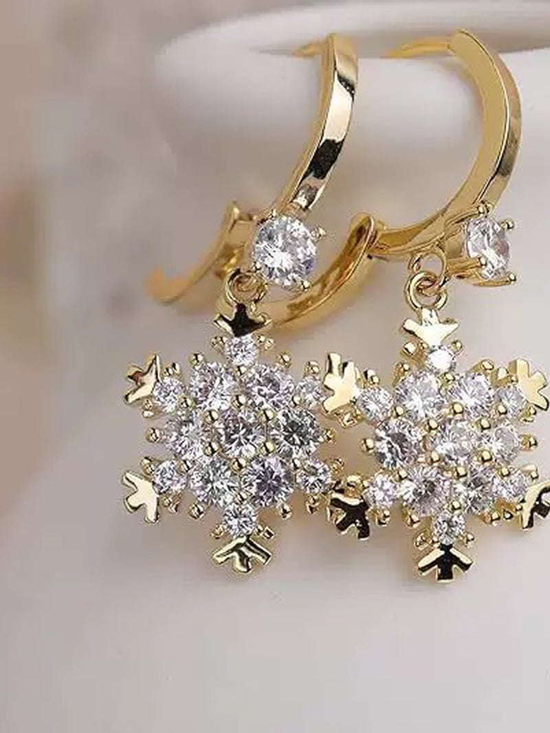 Golden Snowflakes Ohrringe Produktfoto – 18K vergoldete Schneeflocken-Ohrringe mit Zirkonia-Kristallen auf weißem Hintergrund