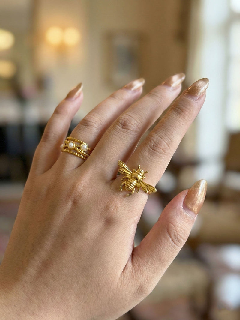 Pearl Lace Perlenring am Finger kombiniert mit goldenen Ringen Indoor natuerliches Licht Nemomatheo