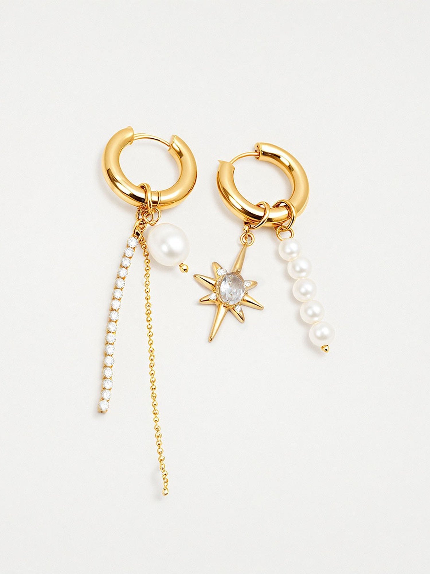 Perla & Stella Ohrringe Produktfoto – asymmetrische goldene Creolen mit Stern-Anhänger, Perlen und Kristallkette auf weißem Hintergrund