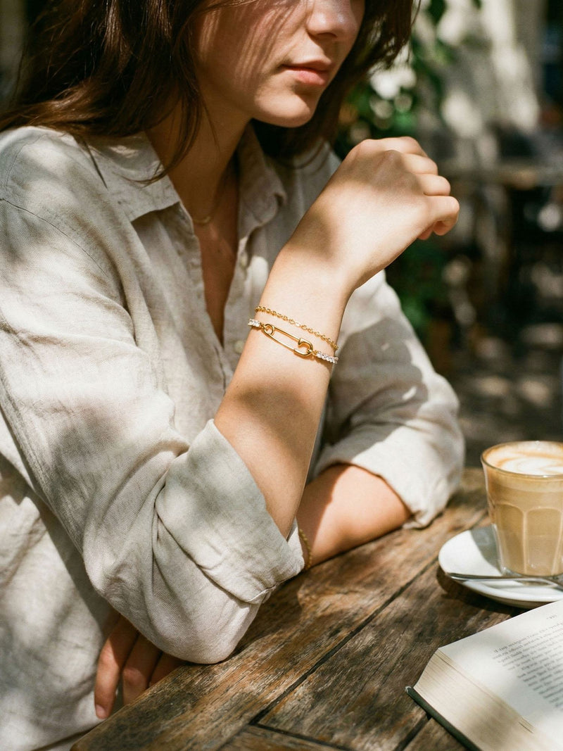 Pin Up Armband am Handgelenk getragen – funkelnde Kristalle und goldener Nadel-Charm im Sonnenlicht