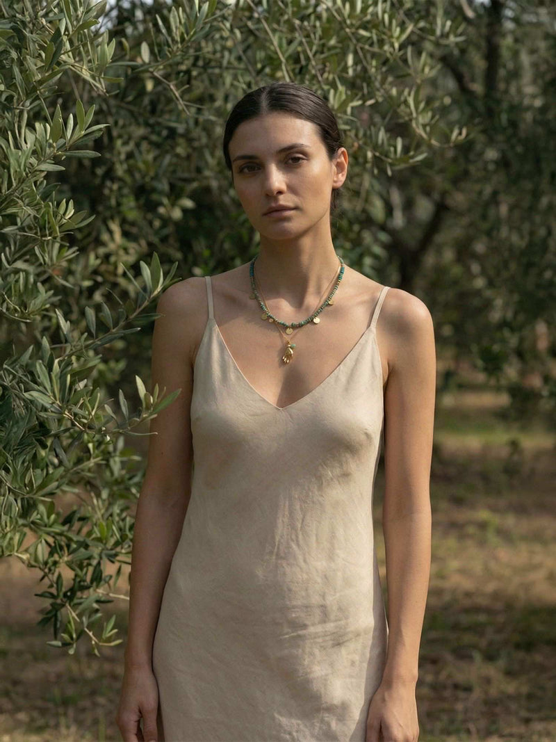 Model trägt Boho Layering Ketten im mediterranen Olivenhain - afrikanische Türkis-Perlen mit goldenem Schutz-Anhänger natürlicher Stil