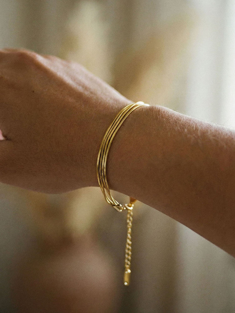 Quintuple Silk Armband am Handgelenk getragen – fuenf goldene Ketten fliessen elegant am Arm