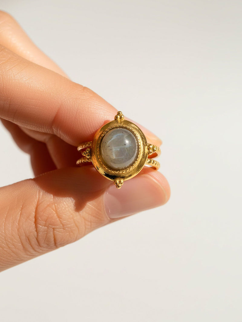 Ring Aurora Filo Detail - vergoldeter Ring mit grauem Labradorit zwischen Fingern - Nahaufnahme