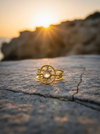 Aurora Notte Ring bei Sonnenuntergang - Goldener Boho Ring auf Felsen mit dramatischem Gegenlicht
