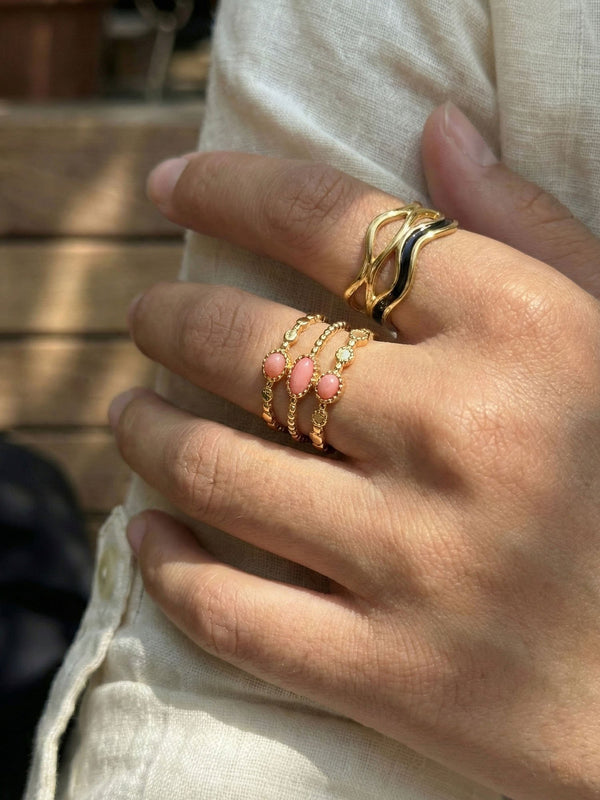 Ring Schichttraeume am Finger getragen Nahaufnahme drei rosa Steine goldener Ring Nemomatheo