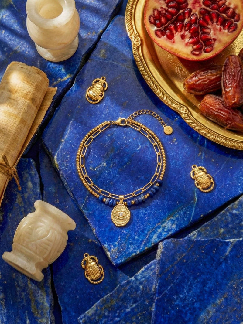 Schutzblick Armband Blau Flatlay – Lapislazuli-Armband auf blauem Stein mit aegyptischen Skarabaeus-Anhaengern Granatapfel orientalisch