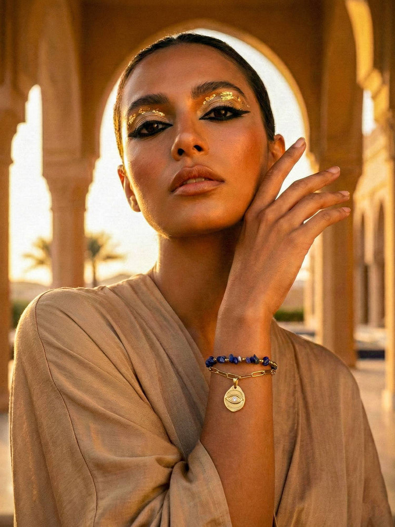 Schutzblick Armband getragen Orient – Lapislazuli-Perlenarmband mit Schutzauge an Frau vor orientalischer Architektur goldenes Licht