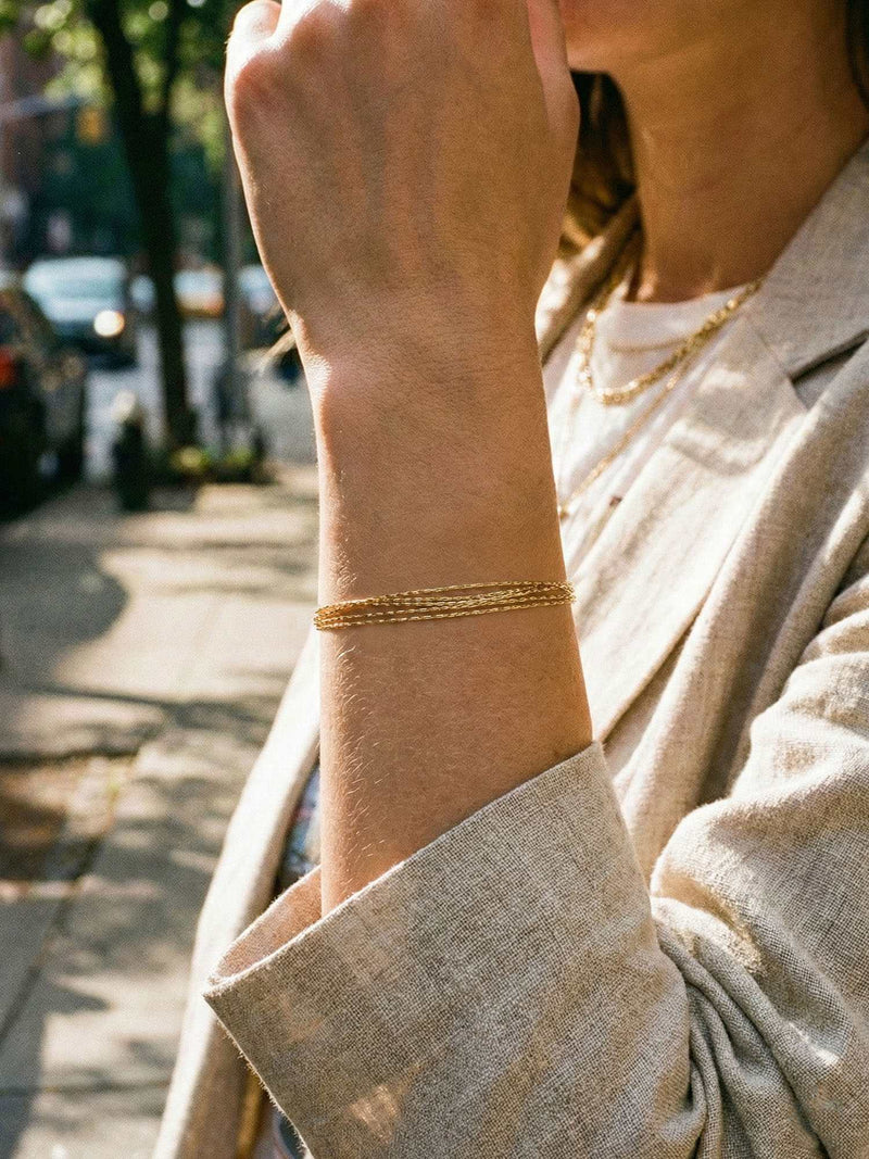 Silk Chains Armband am Handgelenk getragen – goldene Mehrfachketten fliessen elegant am Arm