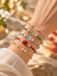 Cinque Elementi: fünf Armbänder in Weiß, Grün, Blau, Rot und Gelb zusammen am Handgelenk; einzeln erhältlich.