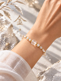 SL63A: Weißes Armband Cinque Elementi Metall mit goldfarbenen Zwischenstücken, am Handgelenk getragen.