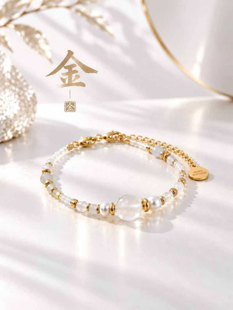 SL63A: Weißes Armband Cinque Elementi Metall mit goldfarbenen Details und dem chinesischen Zeichen 金 im Stillleben.