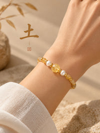 SL63D: Armband Cinque Elementi Erde mit gelben Perlen, einzeln am Handgelenk getragen.