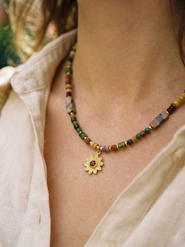 Kette Sonnenblume Totem – Detailaufnahme am Hals getragen, Nahaufnahme Anhaenger und Perlen