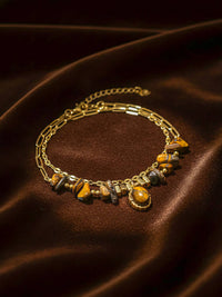 Stein und Glanz Armband Flatlay – Handgefertigtes Tigerauge-Armband mit Naturstein-Anhaenger auf braunem Samt 18K vergoldet