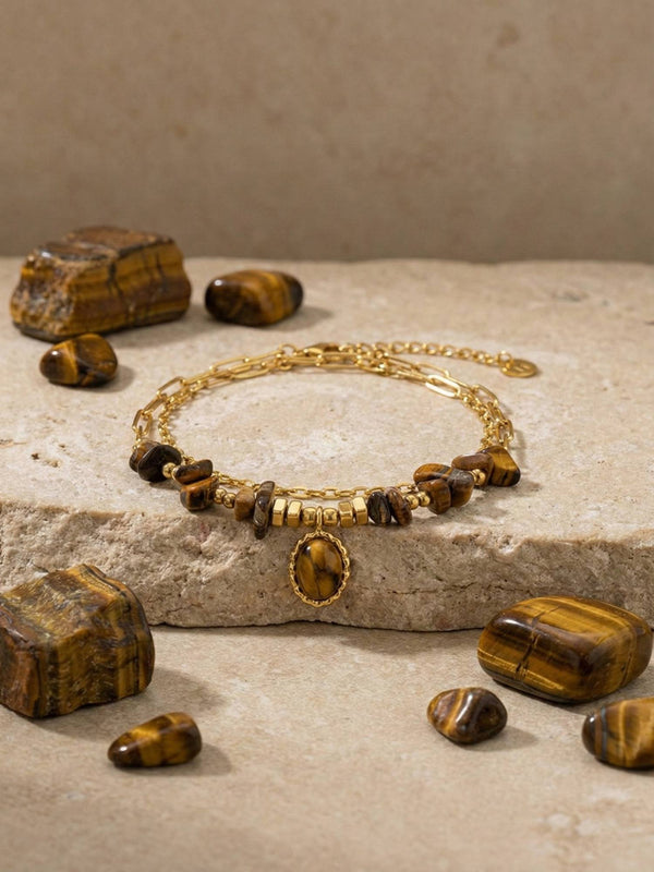 Stein und Glanz Armband Stein Flatlay – Tigerauge-Armband auf Marmor mit losen Tigerauge-Steinen Erdtoene natuerliches Licht