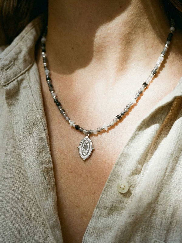 Kette Stern Oval Anhaenger – Detailaufnahme am Hals getragen, Nahaufnahme Anhaenger und Perlen