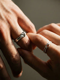 Paar traegt Still Connected Partnerringe - 925 Silber Knotenringe, romantische Handberuehrung