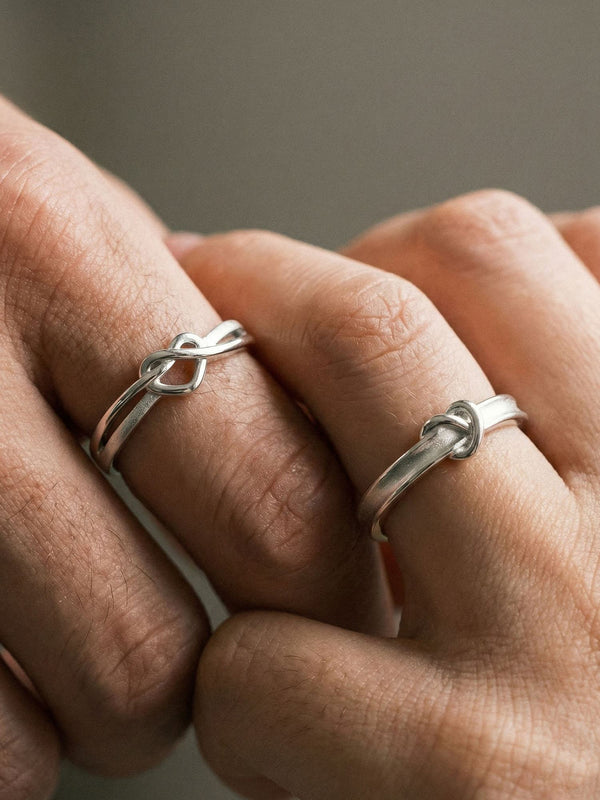 Still Connected Partnerringe getragen - 925 Silber Paarringe mit Knotendesign, Nahaufnahme am Finger