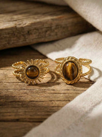 Sunburst Ring Flatlay – vergoldeter Boho-Ring mit Tigerauge in natuerlicher Umgebung
