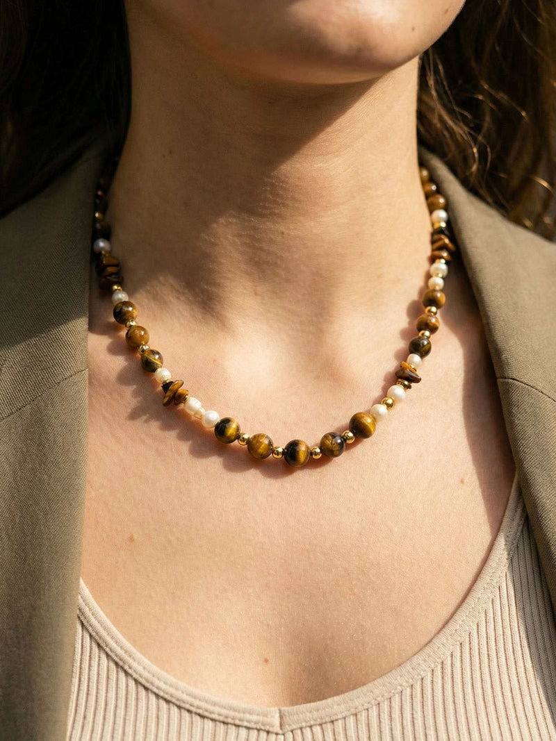 Kette Tigerauge Kurz – Detailaufnahme am Hals getragen, Nahaufnahme Anhaenger und Perlen