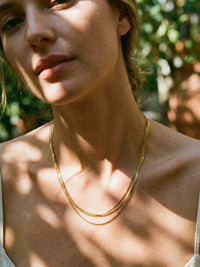 Triple Layer Gold Kette getragen – Model traegt elegante goldene Mehrfachkette