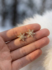 Winterlicht Schneeflocken-Ohrstecker Nahaufnahme in der Hand – goldene Schneeflocken-Ohrringe Groessenvergleich im Winterlicht