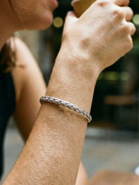 Woven Heritage Frost Armreif am Handgelenk getragen – silberner Flechtarmreif als kuehles Accessoire