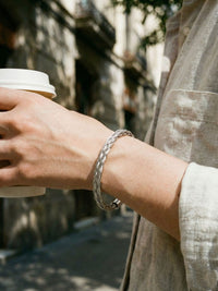Woven Heritage Frost Armreif beim Kaffeetrinken – silberner Flechtarmreif im entspannten Alltag