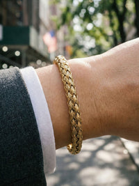 Woven Heritage Royal Armreif am Handgelenk getragen – goldener Flechtarmreif als elegantes Accessoire