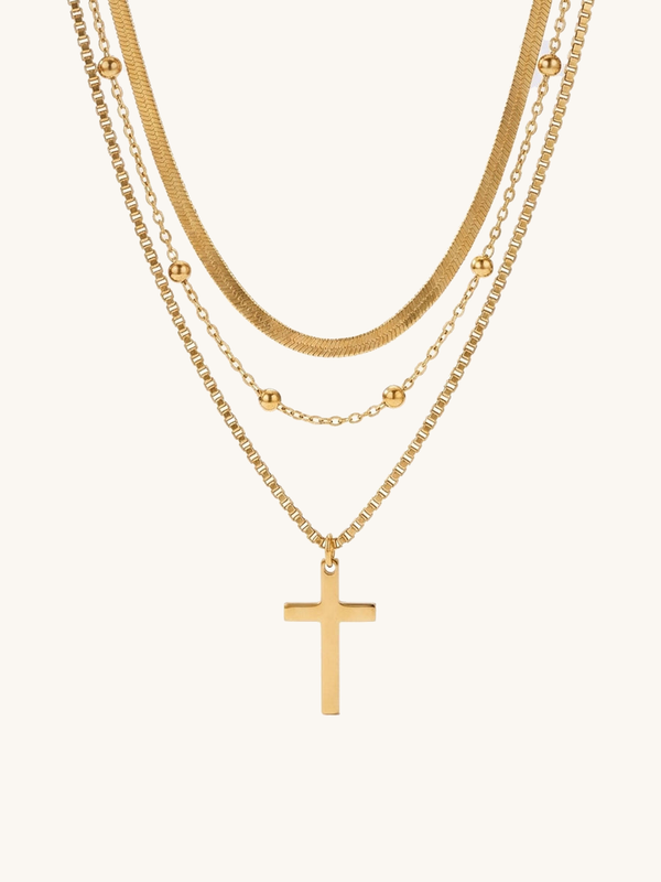 Devotion Kreuz Kette Produktfoto – vergoldete mehrreihige Kette mit Kreuzanhaenger auf weissem Hintergrund